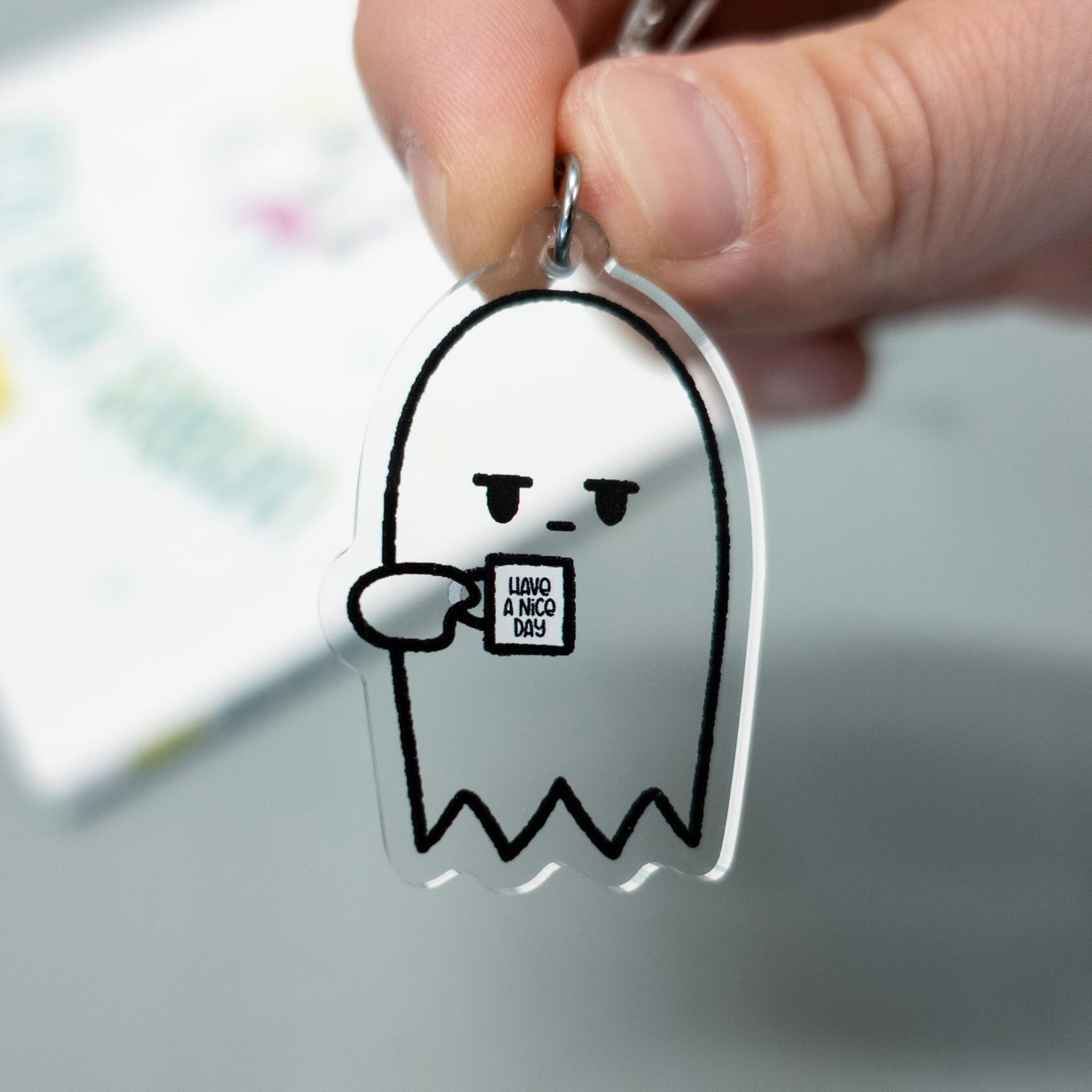 grumpy ghost keychain hanging from hand