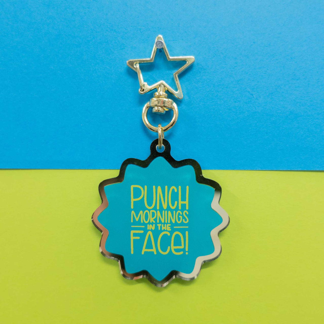 gold edge keychain with words "punch mornings in the face" 