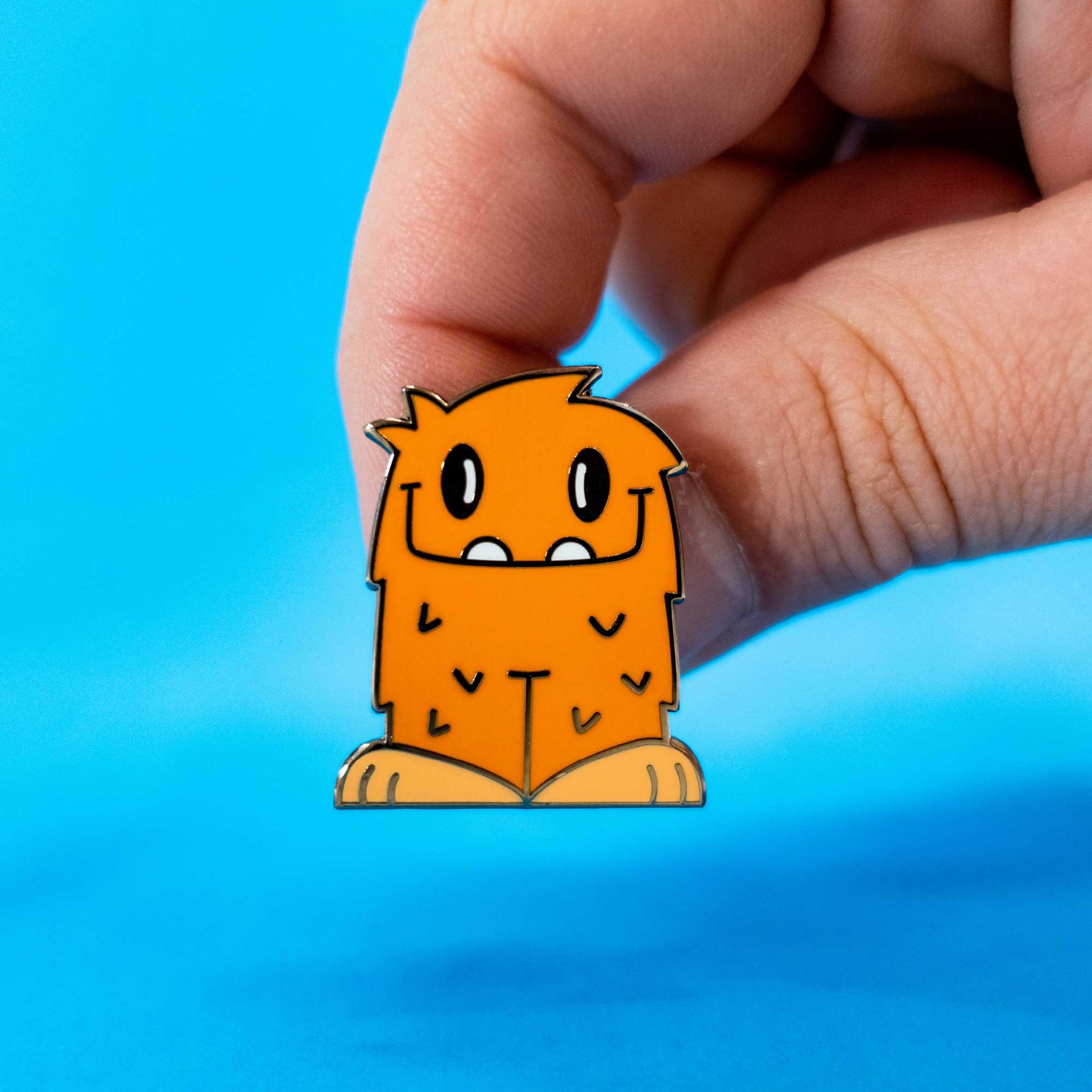 reggie the cute little monster enamel pin in hand