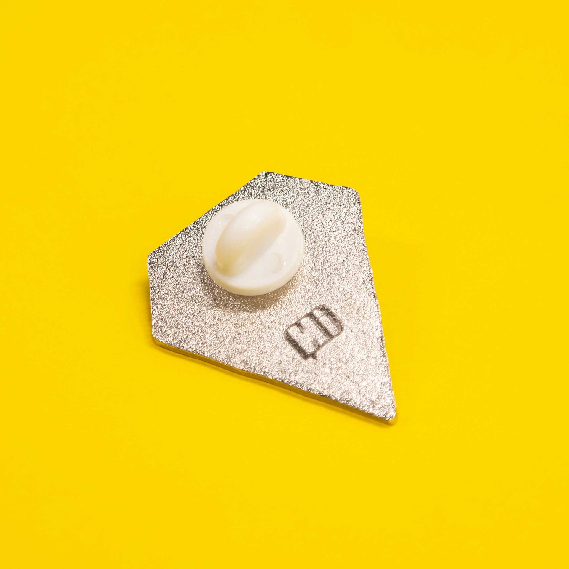back of diamond shaped enamel pin that says "shine on"